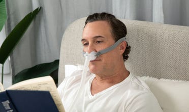 Man reading in bed wearing AirFit P10