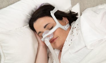 Woman sleeping soundly while wearing AirFit N20 For Her CPAP mask