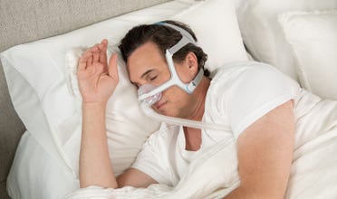 Man sleeps soundly while wearing an AirFit N20 CPAP mask