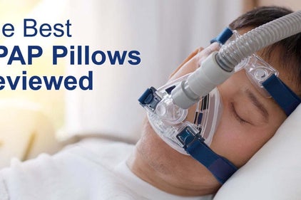 man with a CPAP mask sleeping on a pillow