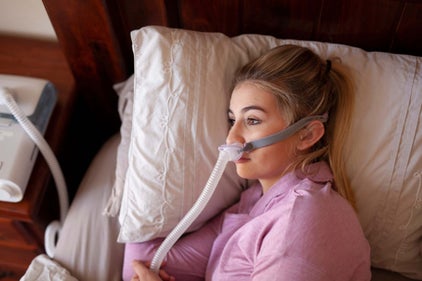 a woman sleeping on her side with an airfit p10 nasal pillow mask