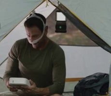 man camping in a tent wearing a dreamwear mask with dreamstation go